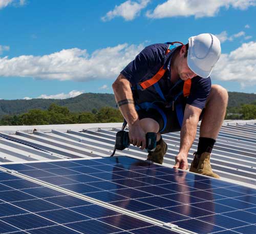 Man Installing Solar Panels On Roof